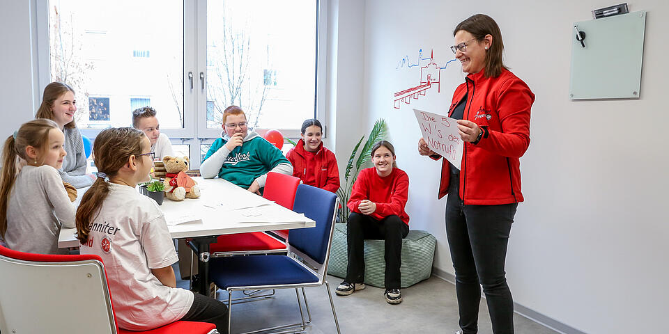 Gruppenstunde im neuen Zentrum: Kinder lernen spielerisch, wie man richtig den Notruf wählt.