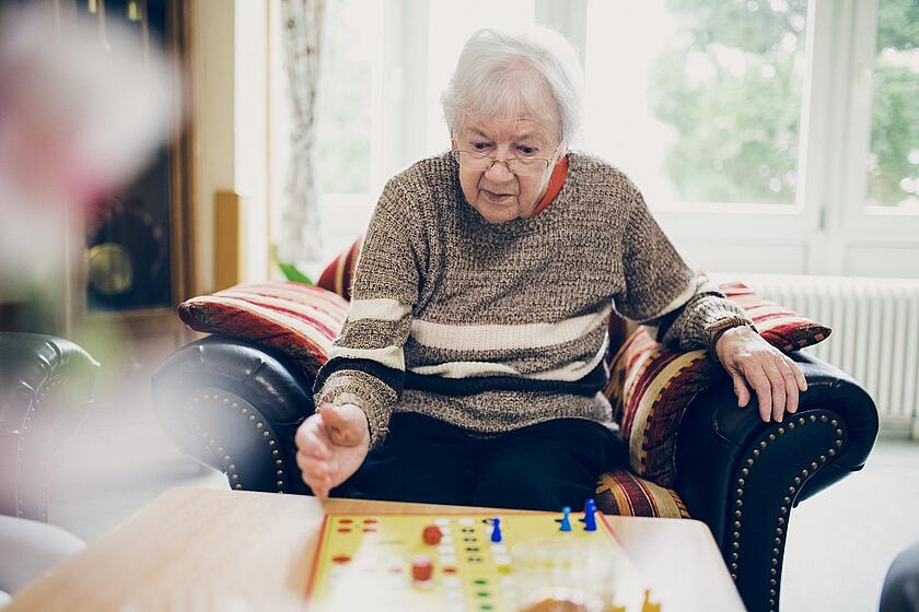 Eine Bewohnerin spielt ein Brettspiel