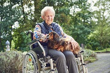 Eine Bewohnerin kuschelt mit einem Hund