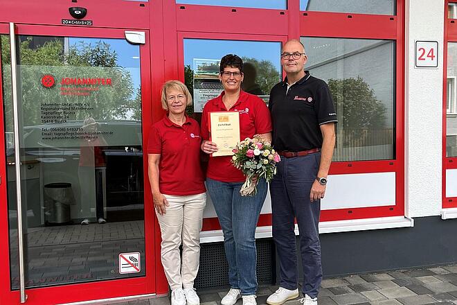 drei Personen, zwei Frauen und ein Mann, vor dem Eingang der Tagespflege Buseck