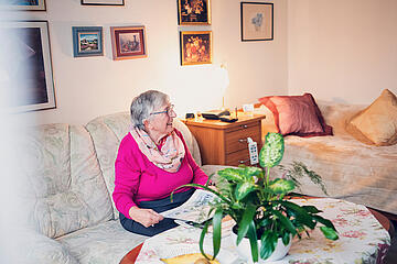 Ältere Dame in rosafarbenem Pullover in Ihrem Zimmer in Ricklingen