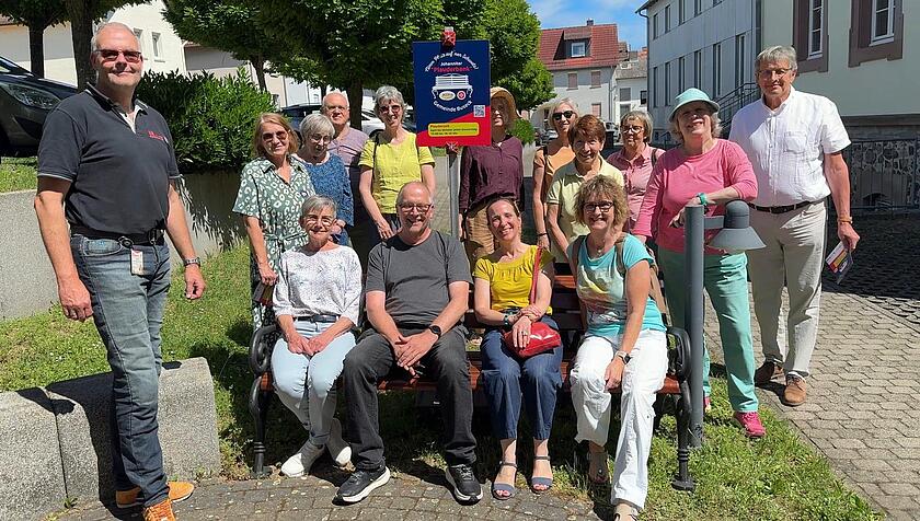 Mehrere Personen auf der neuen Johanniter-Plauderbank in Alten-Buseck