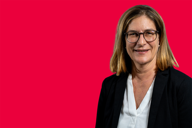 Portrait einer Mitarbeiterin vor rotem Hintergrund