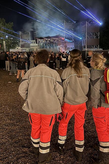 zwei Personen mit Sanitätsdienstrucksack bei einer Veranstaltung