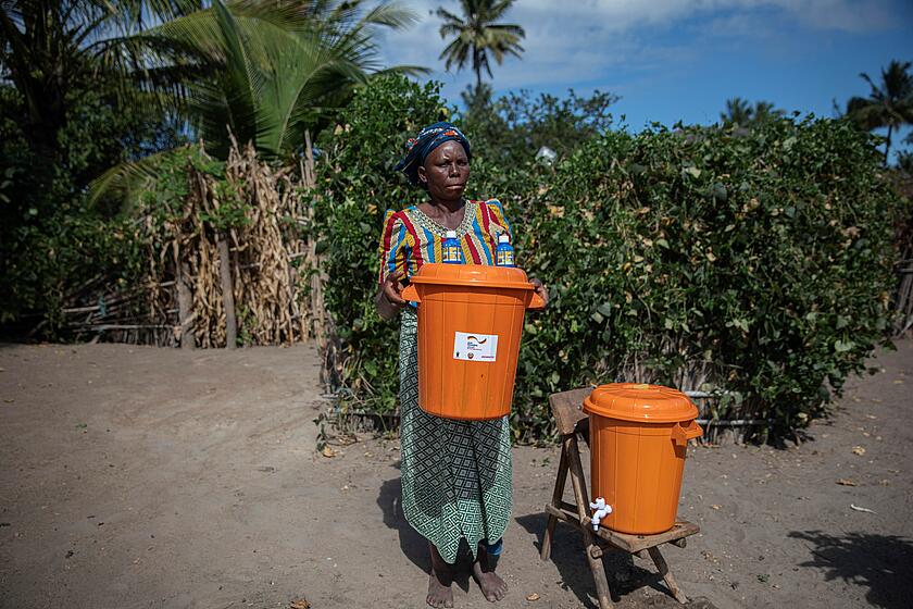 Woman in Mozambique with water buckets