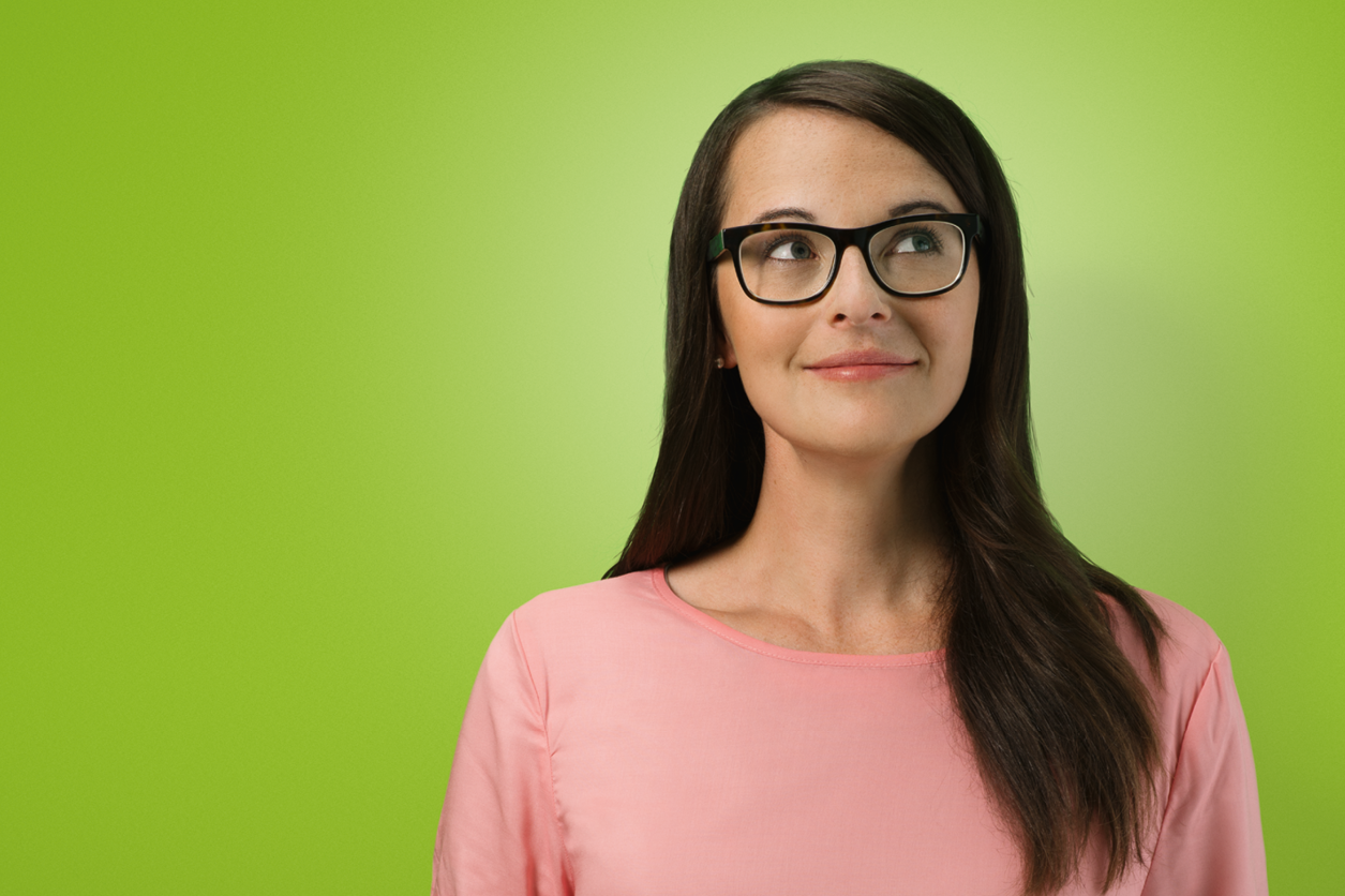 Eine Frau mit Brille auf grünen Hintergrund.