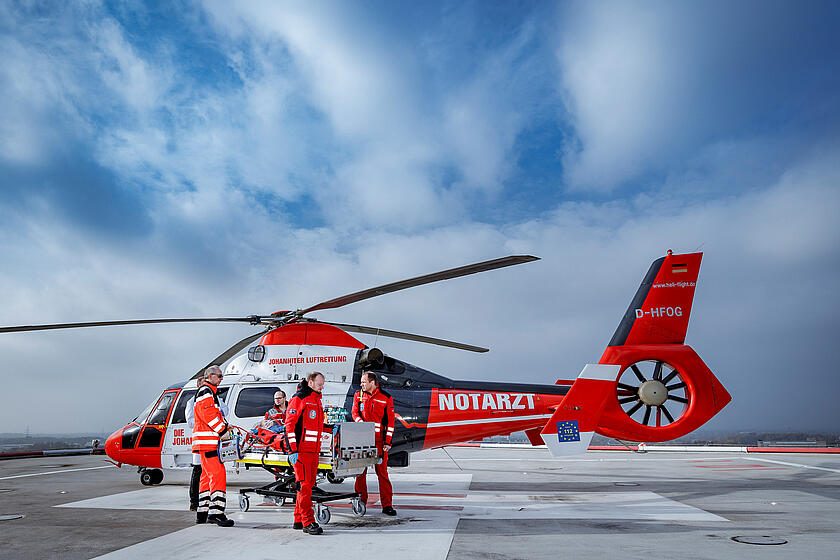 Rettungspersonal vor dem Hubschrauber mit Patiententrage