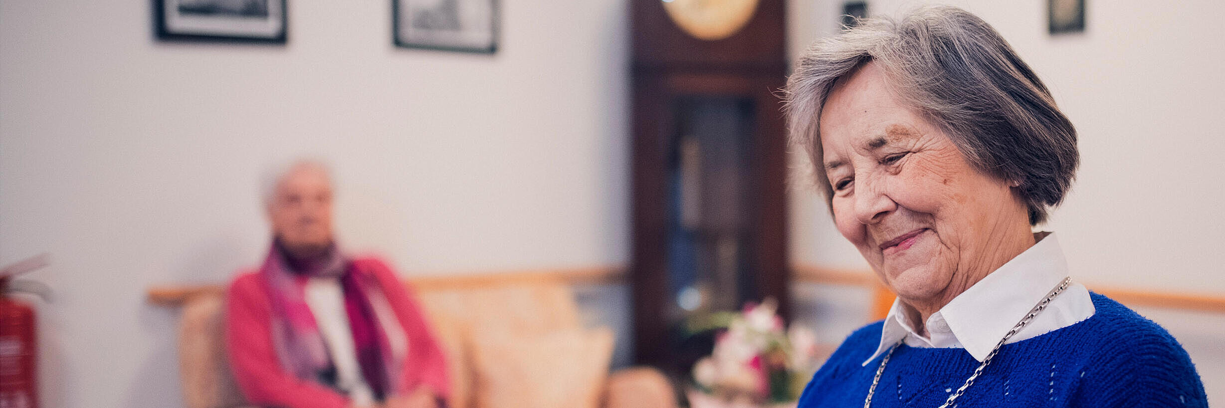 Eine Bewohnerin in blauem Pullover liest im Johanniter-Stift