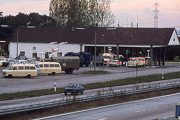 Rettungsfahrzeuge der Johanniter vor einem Gebäude direkt neben der Autobahn.