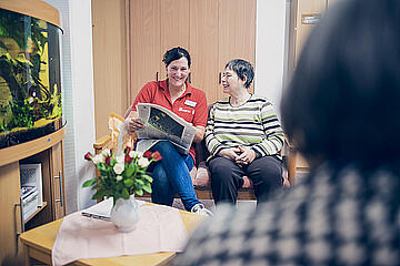 Eine Dame liest einer Seniorin vor