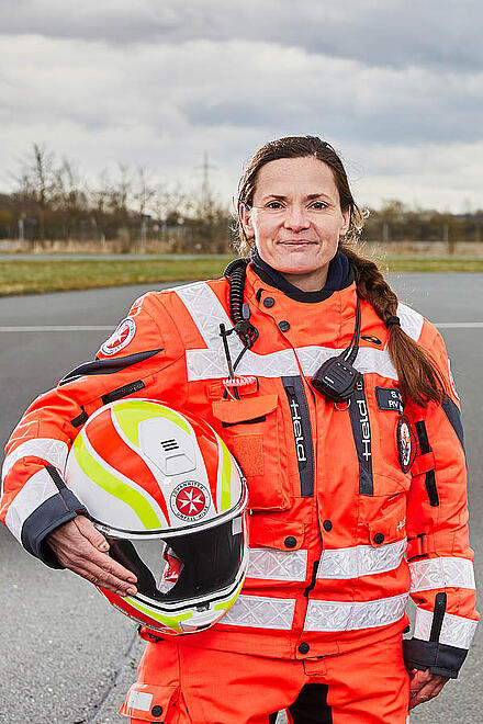 Eine Helferin der Stauhilfe hält ihren Helm und blickt in die Kamera